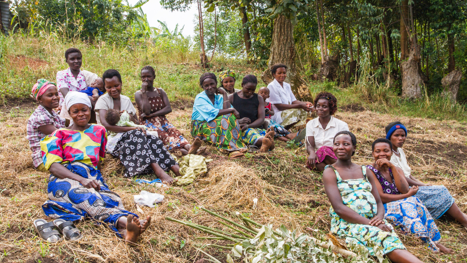 A group of women from the Mpanga Growers Tea Factory in Uganda gathered outside in their community.