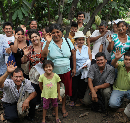 Group of Fair Trade cocoa farmers smiling and waving